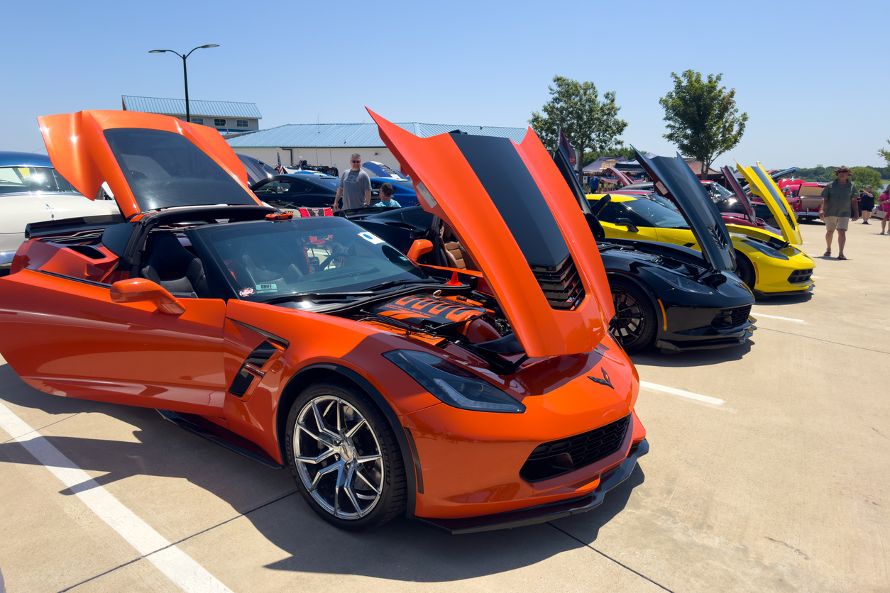Orange and Black Chevrolet Corvette with hood open at local outside car show